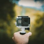 person holding action camera